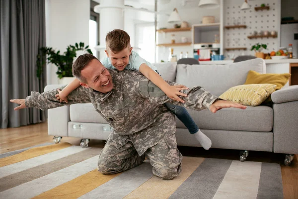 military man playing with son at home