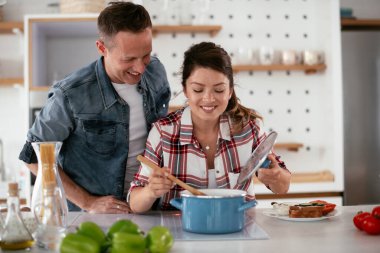 Karı koca mutfakta. Genç çift evde lezzetli yemekler hazırlıyor..