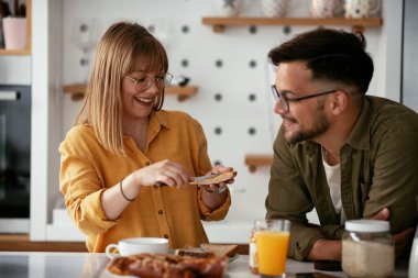 Genç çift evde lezzetli yemekler yapıyor. Sevgi dolu çift mutfakta eğleniyor..
