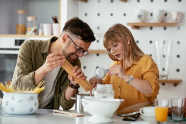 Karı koca mutfakta. Genç çift evde lezzetli yemekler hazırlıyor..