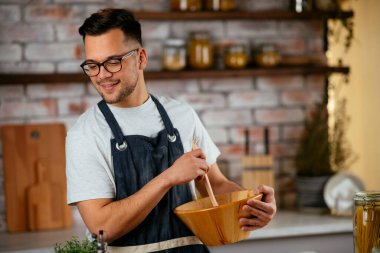 Mutfakta makarna hazırlayan yakışıklı adam. Lezzetli yemek pişiren adam..