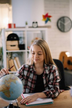 Güzel küçük kız evde ders çalışıyor.