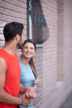 Atletik çift şehirde koştuktan sonra dinleniyor. Mutlu çift sabahları eğleniyor...