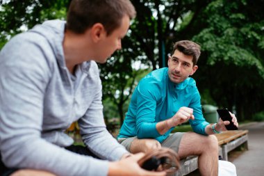 Koşmaktan istirahat eden zinde genç adamlar. Dışarıda antrenman yapan iki arkadaş..