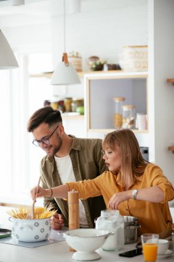 Karı koca mutfakta. Genç çift evde lezzetli yemekler hazırlıyor..