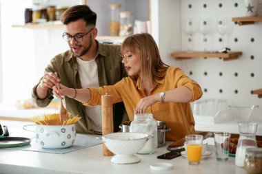 Karı koca mutfakta. Genç çift evde lezzetli yemekler hazırlıyor..