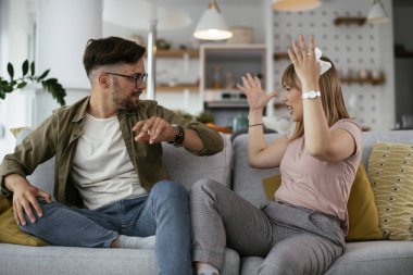 Erkek arkadaşı ve kız arkadaşı kanepede tartışıyor. Kızgın kadın erkek arkadaşına bağırıyor..