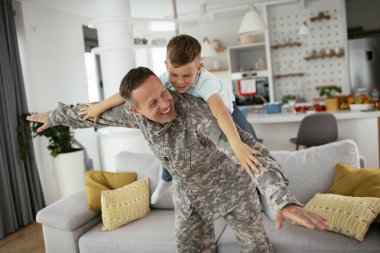 Askerler evlerinde oğluyla oynuyorlar. 