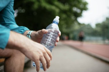 Susamış bir sporcu. Antrenmandan sonra su içen adam..
