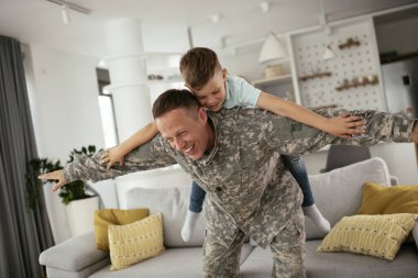 Askerler evlerinde oğluyla oynuyorlar. 