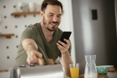 Adam mutfakta kahvaltı yapıyor.