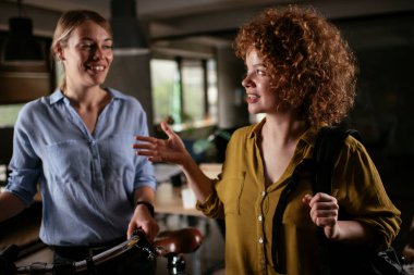 Ofiste konuşan ve gülen mutlu iş kadınları. Kahve molasında güzel kadınlar.