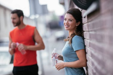 Atletik çift şehirde koştuktan sonra dinleniyor. Mutlu çift sabahları eğleniyor...
