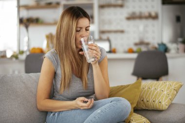 Evde baş ağrısı çeken bir kadın. Soğuk algınlığı için ilaç alan kız..