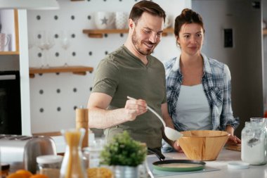 Genç çift evde krep yapıyor. Sevgili çift yemek yaparken eğleniyor..