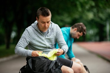 Koşmaktan istirahat eden zinde genç adamlar. Dışarıda antrenman yapan iki arkadaş..