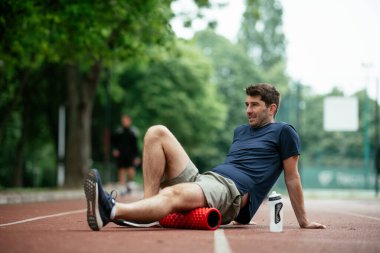 Köpüklü adam geliyor. Sporcu sünger rulo kullanarak esniyor.