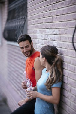 Atletik çift şehirde koştuktan sonra dinleniyor. Mutlu çift sabahları eğleniyor...