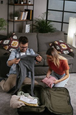 Çift bavul hazırlıyor, yolculuğa hazırlanıyor.