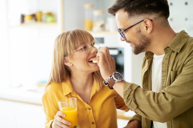 Genç çift evde lezzetli yemekler yapıyor. Sevgi dolu çift mutfakta eğleniyor..