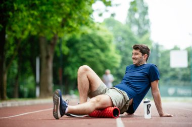 Köpüklü adam geliyor. Sporcu sünger rulo kullanarak esniyor.