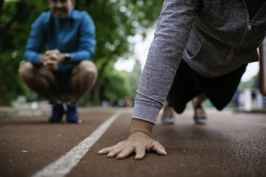 Yarış pistinde egzersiz yapan genç adamlar. Dışarıda antrenman yapan iki genç arkadaş..
