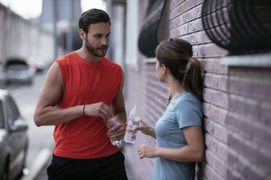 Atletik çift şehirde koştuktan sonra dinleniyor. Mutlu çift sabahları eğleniyor...