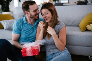 Koca, karısına hediyeyle sürpriz yapıyor. Genç adam karısına hediye kutusu veriyor..