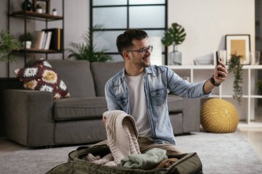 Adam yolculuğa hazırlanıyor, bavulunu hazırlıyor.