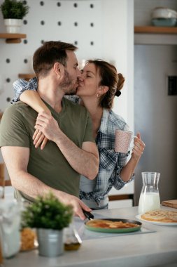 Genç çift evde krep yapıyor. Sevgili çift yemek yaparken eğleniyor..