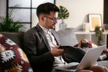 Evde pantolonsuz çalışan bir iş adamı. Genç adam video görüşmesi sırasında bilgisayarı kullanıyor..