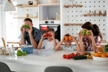 Evde genç ve mutlu bir aile yemeği. Annem ve babam oğullarımla kahvaltı hazırlıyorlar..