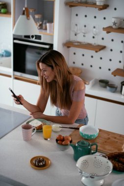 Mutfaktaki kadın. Mutfakta telefon kullanan güzel bir kadın..