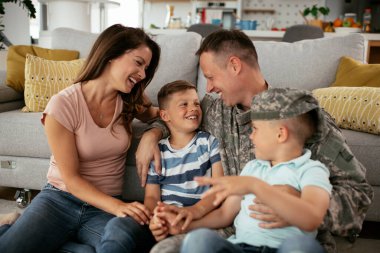 Mutlu aile kanepede birlikte vakit geçiriyor. 