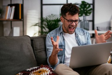 Adam evde çalışıyor, dizüstü bilgisayar kullanıyor.