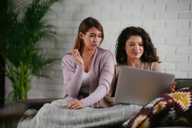 Kız arkadaşlar evde dizüstü bilgisayardan müzik dinlerler. Kızlar apartmanda eğleniyor..