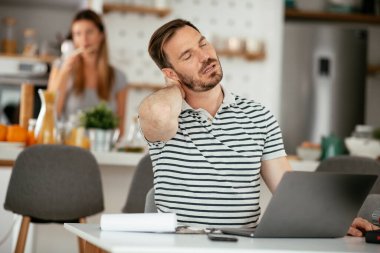 Genç işadamının sırtı ağrıyor. Evde çalışan yakışıklı adam..