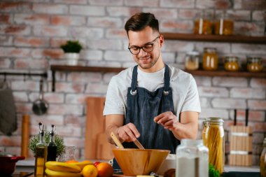 Mutfakta makarna hazırlayan yakışıklı adam. Lezzetli yemek pişiren adam..