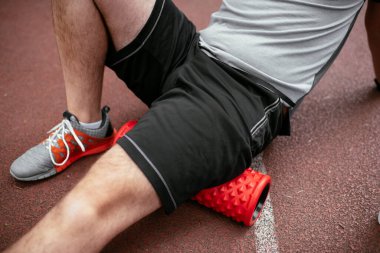 Köpüklü adam geliyor. Sporcu sünger rulo kullanarak esniyor.