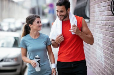 Atletik çift şehirde koştuktan sonra dinleniyor. Mutlu çift sabahları eğleniyor...