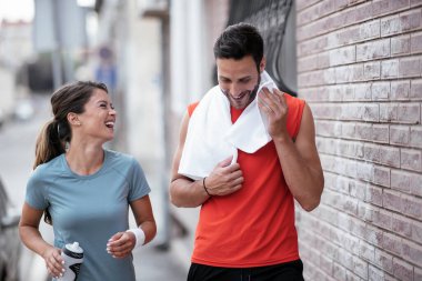Atletik çift şehirde koştuktan sonra dinleniyor. Mutlu çift sabahları eğleniyor...