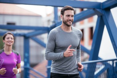 Atletik çift şehirde koşuyor. Mutlu çift dışarıda antrenman yapıyor..