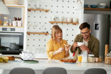 Genç çift evde lezzetli yemekler yapıyor. Sevgi dolu çift mutfakta eğleniyor..