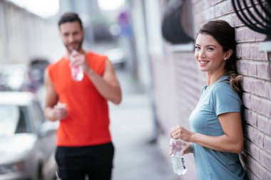 Atletik çift şehirde koştuktan sonra dinleniyor. Mutlu çift sabahları eğleniyor...