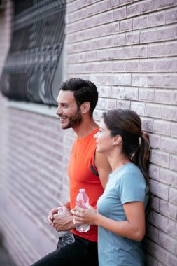 Atletik çift şehirde koştuktan sonra dinleniyor. Mutlu çift sabahları eğleniyor...