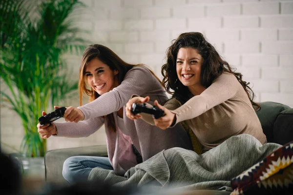 Beautiful young women playing video games at home