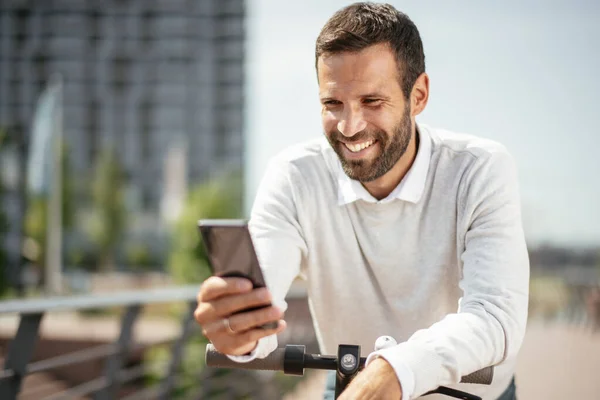 Mladý Obchodník Venku Hezký Podnikatel Pomocí Telefonu Svém Elektrickém Skútru — Stock fotografie