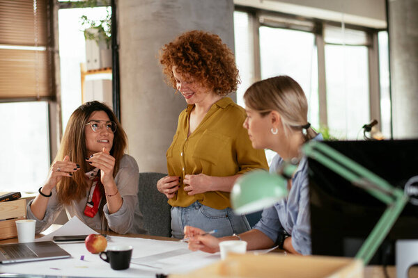 Бизнесвумен, работающих над новым проектом. Коллеги обсуждают работу в офисе.