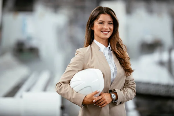 Portrait of an industrial woman engineer standing in a factory.