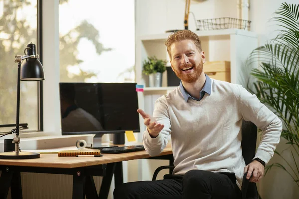 Businessman with ginger hair working in the office at his workplace